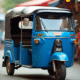 Tuk tuk bleu vif dans un marché urbain en plein jour