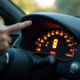 Main de conducteur pointant vers voyant de pression des pneus allumé